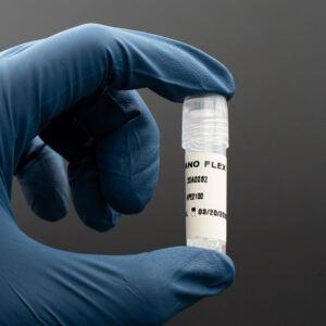 Hand holding a vial labeled "Nano Flex" against a dark background, showcasing a biologics product for cosmetic and research purposes.